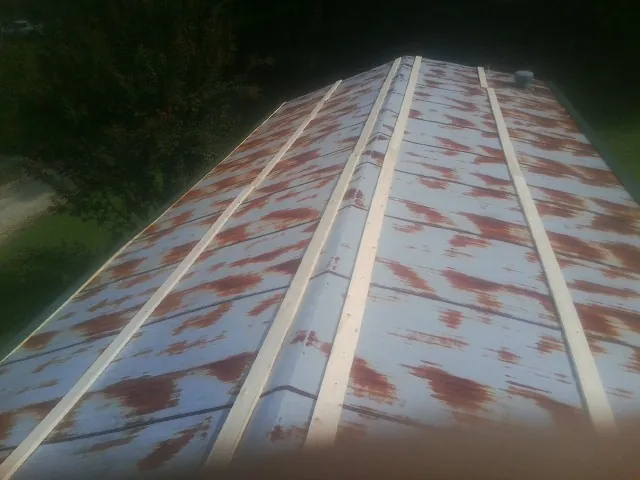 Rusted metal roof panels with new wood purlins before replacement — Storm Damage Roof Repair in Coltons Point by Roofing Brothers