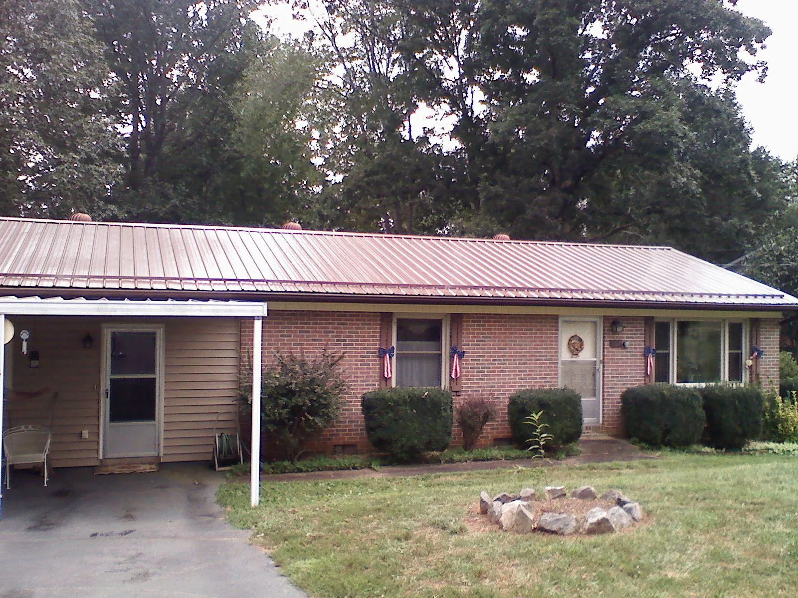 Bronze metal roof and carport on a brick ranch home — Roof Repair work by our crew in Coltons Point